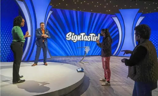  ?? Pittsburgh Post-Gazette ?? Roxie Dummett, left, and host Dan Cook use American Sign Language to clarify ASL grammar with fellow performer Lisa McBee and ASL judge MJ Shahen during a “SignTasTic!” rehearsal in January 2022 at WQED Studios in Oakland.