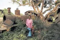  ??  ?? Train driver Rafid Kabadi, 49, poses with his grandson in front of an abandoned train that he used to drive in Janakpur.