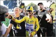  ?? ASSOCIATED PRESS ?? France’s Julian Alaphilipp­e, wearing the overall leader’s yellow jersey, celebrates after winning the 13th stage of the Tour de France on Friday, an individual time trial over 27.2 kilometers (16.9 miles).