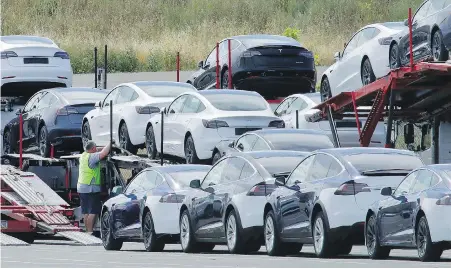  ?? BEN MARGOT, THE ASSOCIATED PRESS ?? Tesla cars are loaded onto carriers at the Tesla electric car plant in Fremont, California. Tesla’s automated driving systems have come under scrutiny by safety regulators in recent months.