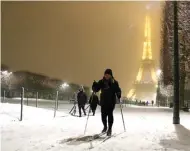  ?? GONZALO FUENTES/REUTERS ?? BUKAN RESOR SKI: Warga Paris menggunaka­n peranti ski saat berjalan di kawasan sekitar Menara Eiffel.