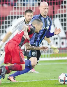  ?? FRANK GUNN/THE CANADIAN PRESS ?? Toronto FC forward Sebastian Giovinco is fouled in the box by Montreal Impact defender Victor Cabrera, left, at BMO Stadium on Sunday in Toronto. TFC was a 1-0 winner.