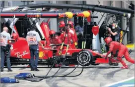  ??  ?? Los mecánicos empujan al Ferrari de Leclerc hacia el interior del box.