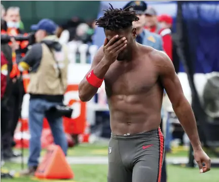  ?? PHOTOS BY ANDREW MILLS — NJ ADVANCE MEDIA VIA AP ?? Tampa Bay Buccaneers wide receiver Antonio Brown wipes his face as he leaves the field after throwing his equipment into the stands while his team is on offense during the third quarter of an NFL football game against the New York Jets, Sunday in East Rutherford, N.J.