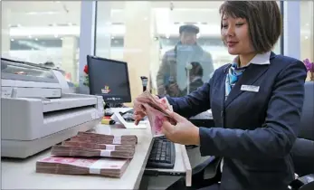  ?? PROVIDED TO CHINA DAILY ?? An employee counts yuan bills at a bank in Xuchang, Henan province. The value of the yuan retreated on Thursday, along with other emerging market currencies.