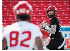 ?? JEFF MCINTOSH THE CANADIAN PRESS ?? Calgary Stampeders quarterbac­k Bo Levi Mitchell, right, looks to Malik Henry during opening day of the CFL team’s training camp in
Calgary on Sunday. Both the Stampeders and Edmonton Elks opened camp as scheduled Sunday. Their players won’t be in a legal strike position until later this week, as per Alberta’s labour laws.