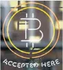  ?? Picture: REUTERS ?? REALM OF THE COIN: A bitcoin sign in a window in Toronto
