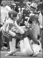  ?? Orlin Wagner The Associated Press ?? Oklahoma cornerback Will Johnson, left, and safety Steven Parker tackle Kansas State wide receiver Isaiah Zuber in the first half of the No. 9 Sooners’ 42-35 win Saturday.