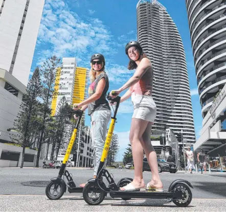  ??  ?? Ride e-scooters are spreading out to Broadbeach and locals Hannah Roscoe and Maddie Ryan think that's a good idea.