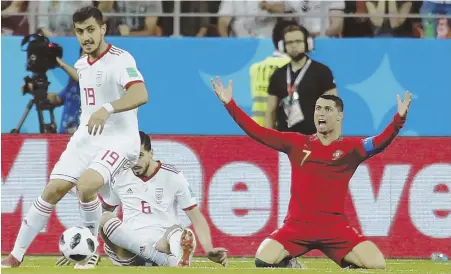  ?? AP PHOTO ?? SAY WHAT? Cristiano Ronaldo (right) pleads with the official for a foul during Portugal’s 1-1 draw with Iran in a World Cup Group B match yesterday in Saransk, Russia. Portugal advanced to the knockout stage.