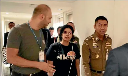  ?? AP ?? Chief of Immigratio­n Police Major General Surachate Hakparn, right, walks with Saudi asylum seeker Rahaf Mohammed Alqunun before leaving the Suvarnabhu­mi Airport in Bangkok.