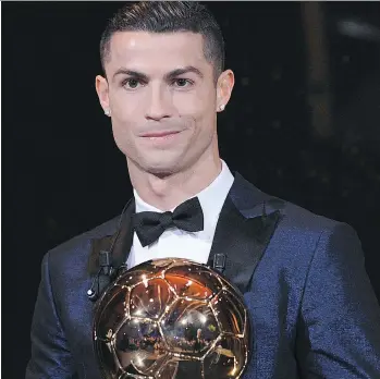  ?? FRANCK FAUGERE/AFP/GETTY IMAGES ?? Cristiano Ronaldo shows off his record-equalling fifth Ballon d’Or as soccer’s top player of the year Friday in Paris. The Real Madrid forward beat out Lionel Messi and Neymar.