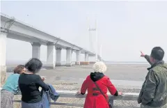  ?? REUTERS ?? A man points at the New Yalu River Bridge, which connects China’s Dandong New Zone and North Korea’s Sinuiju, in Dandong, Liaoning province.