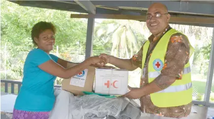  ?? Photo: Josaia Ralago ?? Kelera Tokailoqi of Togo Village in Qamea receives donations from Red Cross Officer North Vili Taufa Cocker.