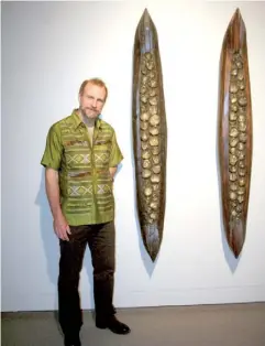  ??  ?? Artist Brad Copping stands beside his piece “Untitled (Black Canoes)”, which is currently on display at the Moose Jaw Museum & Art Gallery.