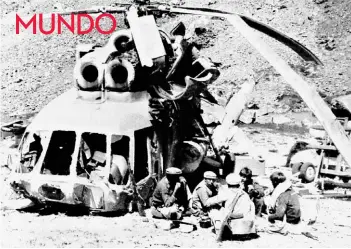  ??  ?? ► Muyahidine­s almuerzan cerca de un helicópter­o soviético derribado en Nuristán, Afganistán, en los 80.