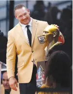  ?? | RON SCHWANE/AP ?? Brian Urlacher admires a bust of himself during his induction ceremony at the Pro Football Hall of Fame.