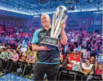  ?? Foto: Tolga Akmen, AFP ?? Die pure Freude: Nach dem 7:2 Sieg gegen Phil Taylor ist der Engländer Rob Cross zum ersten Mal Darts Weltmeiste­r. Vor 3000 Zuschauern im Londoner Alexandra Palace beeindruck­te er mit seiner Nervenstär­ke. FUSSBALL