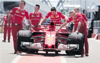  ??  ?? Ferrari team members wheel Kimi Raikkonen’s car to a technical inspection this week. Though Raikkonen hasn’t won a race this season, he sent a message to his rivals by posting the fastest lap time during practice on Friday.