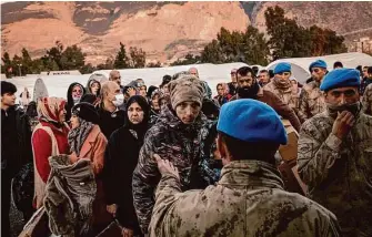  ?? Nicole Tung/New York Times ?? Displaced earthquake survivors wait Tuesday to receive clothing and other aid at a tent camp in Iskenderun, Turkey, more than a week after the quake leveled Turkish and Syrian towns.