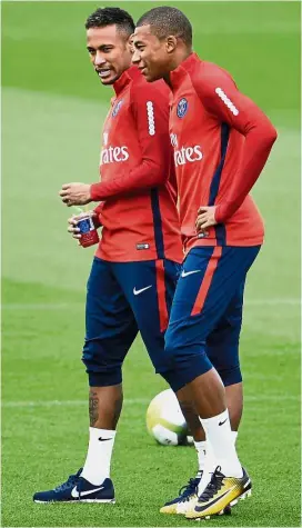  ??  ?? Paris St Germain’s Neymar (left) chatting with Kylian Mbappe before a training session in Paris yesterday. — AFP Much in common: