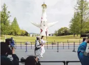  ?? AP ?? VIVA LA LLAMA. Un exatleta japonés lleva la llama olímpica como parte de un relevo que se corre sin presencia de público.