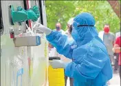  ?? ANI ?? A medical staffer in PPE suit prepares a swab sample collection kit at Police Lines in Gurugram on Monday.