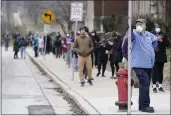  ?? THE ASSOCIATED PRESS ?? Voters observe social distancing guidelines as they wait in line to cast ballots in the presidenti­al primary election in Milwaukee on April 7.