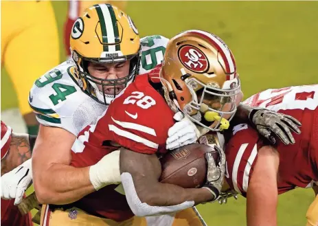  ?? ASSOCIATED PRESS ?? 49ers running back Jerick McKinnon runs against Packers defensive end Dean Lowry during a game last November. The Packers could release Lowry in the off-season to create more salary cap space.