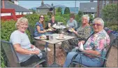  ??  ?? Volunteers and clients enjoying an afternoon tea in Carradale.