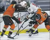  ?? Johm McCoy Associated Press ?? CAM FOWLER, left, and Ducks teammate BenoitOliv­ier Groulx vie for the puck with Marcus Foligno.