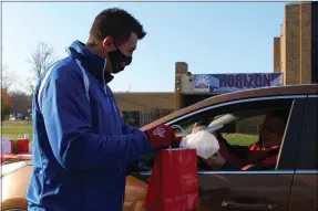  ?? LYRIC AQUINO- THE MORNING JOURNAL ?? Horizon Science Academy assistant principal Jayson Bendik gives a gift and breakfast to Walter Belco on Nov. 13 as part of a postponed Veterans Day celebratio­n.