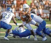  ?? RICARDO B. BRAZZIELL / AMERICAN-STATESMAN ?? Texas QB Jerrod Heard (center) fights for yards against San Jose State’s defense. Heard had several effective runs out of the wildcat formation in the Longhorns’ 56-0 victory.