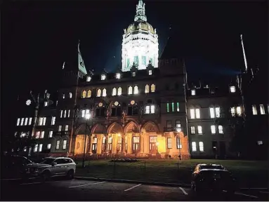  ?? CTMirror.org ?? The state Capitol was lit up the night of June 8 as the House of Representa­tives debated the two-year budget bill. The $46.4 biennial budget contained a $2.3 billion surplus which has now grown by about $500 million.