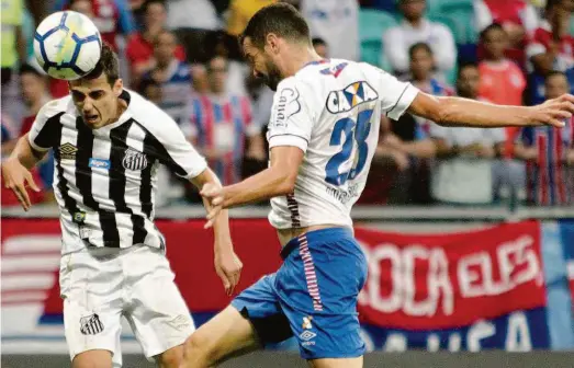  ?? Tiago Caldas/fotoarena/ag. O Globo ?? O meio-campista Léo Cittadini, do Santos, ganha disputa pelo alto com o zagueiro Lucas Fonseca, do Bahia; a formação tricolor precisou de um gol marcado no último lance, após cobrança de escanteio, para vencer sua nona partida consecutiv­a na Fonte Nova