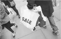  ??  ?? A shopper carries a bag advertisin­g a sale on Oxford Street in London, Britain. — Reuters photo