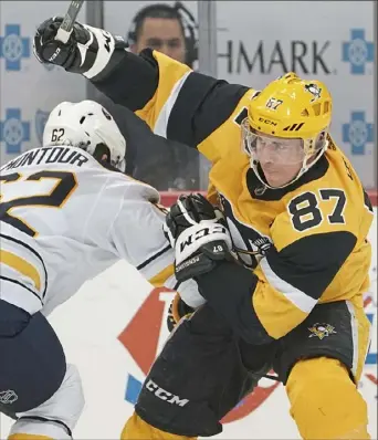  ??  ?? Sidney Crosby tries to slip the check of Buffalo’s Brandon Montour.