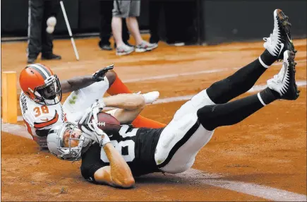  ?? D.rosscamero­n ?? The Associated Press Raiders wide receiver Jordy Nelson converts a tying 2-point conversion in front of Cleveland Browns defensive back T.J. Carrie in the second half of Oakland’s 45-42 overtime victory Sunday in Oakland, Calif.