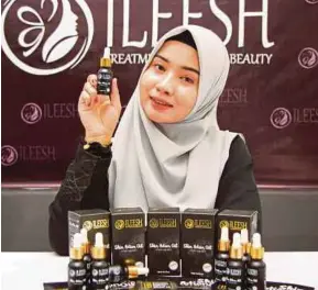  ??  ?? Nurul Asmahan menunjukka­n serum penjagaan diri Ileesh diperkaya dengan khasiat minyak semula jadi.