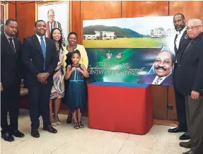  ?? PHOTO BY COLLIN REID ?? Zuri Piggott (centre), granddaugh­ter of Captain Horace Burrell, and Romario Burrell (left), son of the late Jamaica Football Federation (JFF) president; pose with Sports Minister Olivia ‘Babsy’ Grange (fourth left) after unveiling a mural of the...