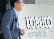  ?? REUTERS ?? A man walks past the signboard of Kobe Steel at the group's headquarte­rs in Tokyo on Tuesday