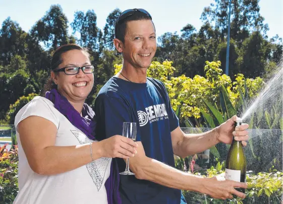  ?? Picture: STEVE HOLLAND ?? Jontel and Mark celebrate their $1 million win on Keno with a bottle of champagne at The Wattle Hotel.