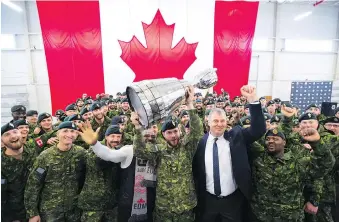  ?? JONATHAN HAYWARD/THE CANADIAN PRESS ?? Cpl. Cody Williamson of Smithers, B.C., hoists the Grey Cup alongside CFL commission­er Randy Ambrosie on Tuesday at CFB Edmonton.