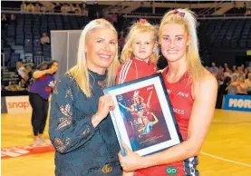  ?? Photo / Photosport ?? Tactix coach Marianne Delaney-Hoshek presented Jane Watson with a framed tribute to mark her 150th Premiershi­p match.