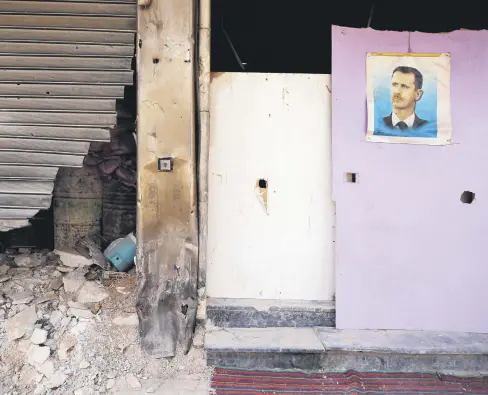  ??  ?? A picture of Syrian regime leader Bashar Assad is seen hanging in the Yarmouk Palestinia­n camp in Damascus, Syria, Oct.10, 2018.