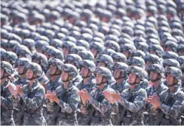  ?? — AFP ?? Chinese soldiers applaud during a military parade at the Zhurihe training base in China’s northern Inner Mongolia region on Sunday.