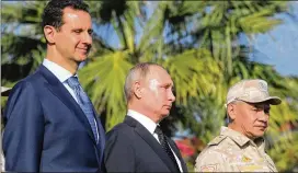  ?? MIKHAIL KLIMENTYEV / SPUTNIK VIA AP ?? Presidents Bashar Assad (left) of Syria and Vladimir Putin of Russia, joined by Russian Defense Minister Sergei Shoigu, watch a procession of troops Monday at Hemeimeem air base in Syria. Putin later visited Egypt and Turkey.