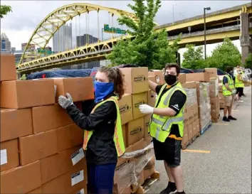  ?? Matt Freed/Post-Gazette ?? Volunteers help prepare boxes for a food drive organized by the Greater Pittsburgh Community Food Bank, Pittsburgh Riverhound­s SC and Highmark Stadium Thursday on the South Shore.