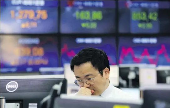  ?? AHN YOUNG-JOON/AP ?? A currency trader works at the KEB Hana Bank in Seoul on Thursday. Risk is a personal thing that means building the right portfolio to fit your needs, says Tom Bradley.