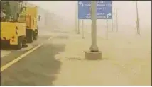  ??  ?? Roads covered with sand blown from the desert by wind during the bad weather.